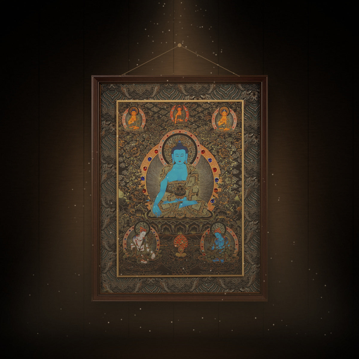 Medicine Buddha black and gold thangka hanging in a room under warm light