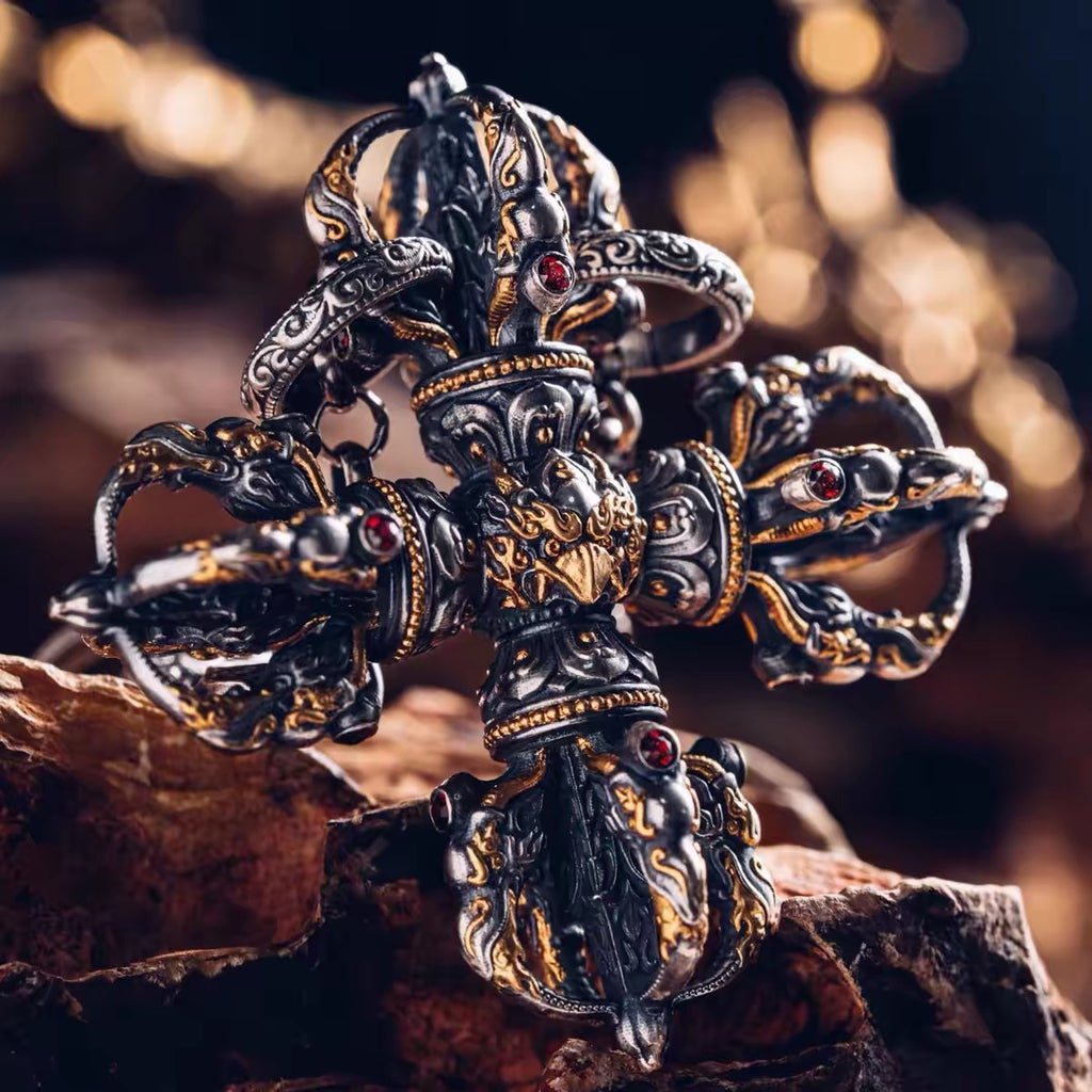 Fire-gilded crossed vajra held in the hand, natural garnets set into every makara head