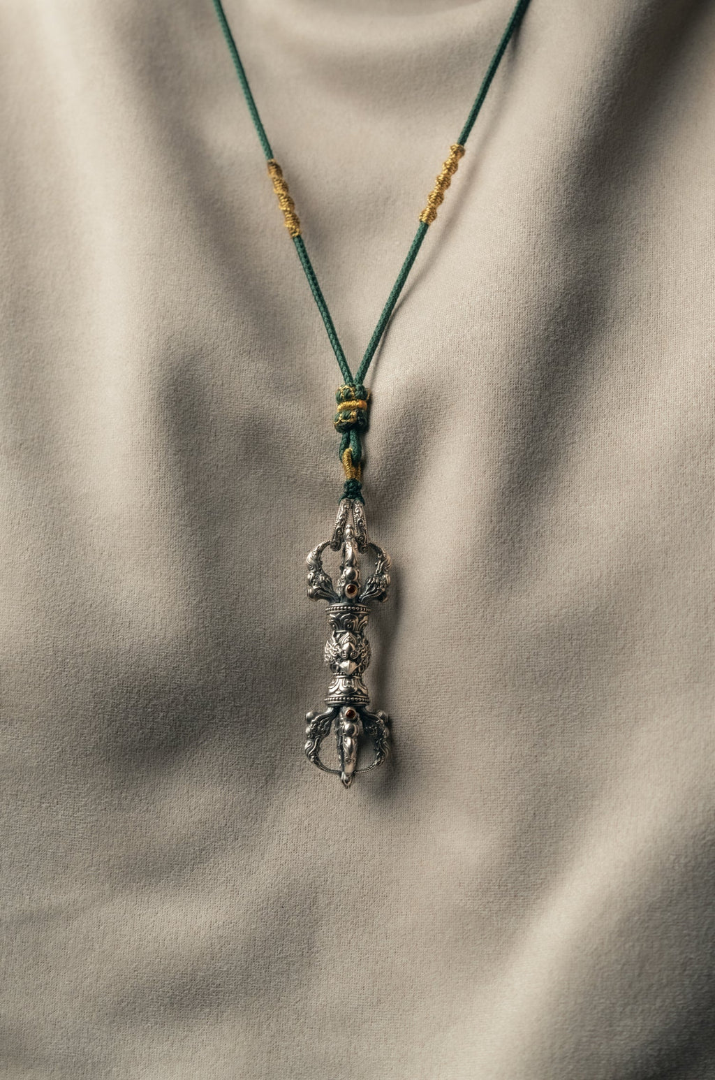 Macro of the lotus throne collars above and below the garuda, beaded borders in silver