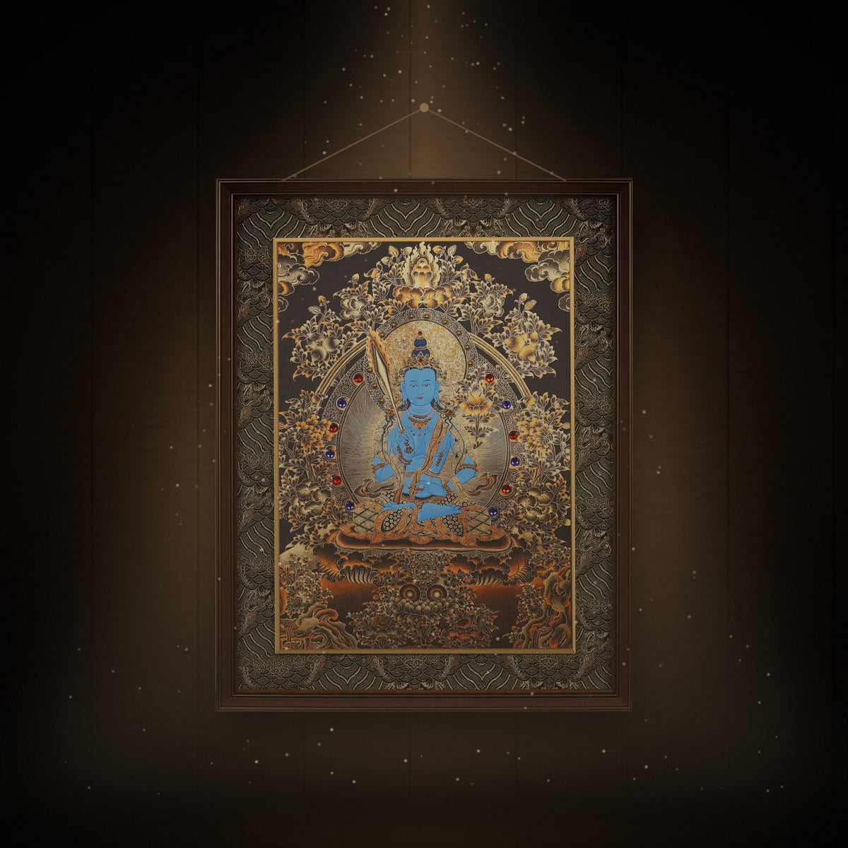 Akashagarbha black and gold thangka hanging in a room under warm light