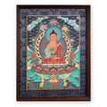 Amitabha Buddha thangka, framed in indigo silk brocade, on a white background