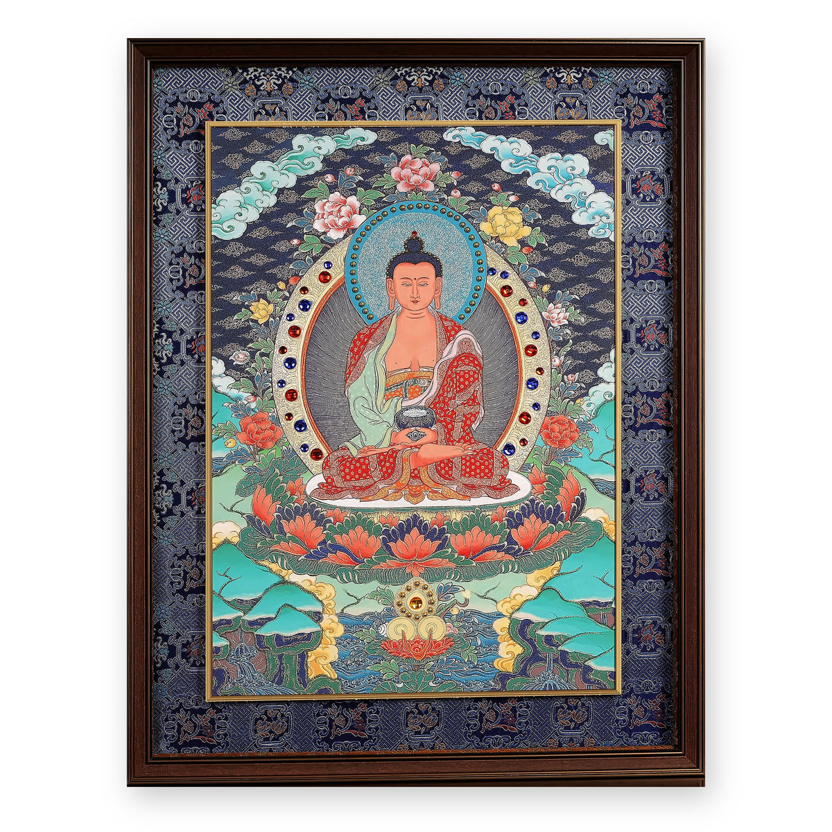 Amitabha Buddha thangka, framed in indigo silk brocade, on a white background