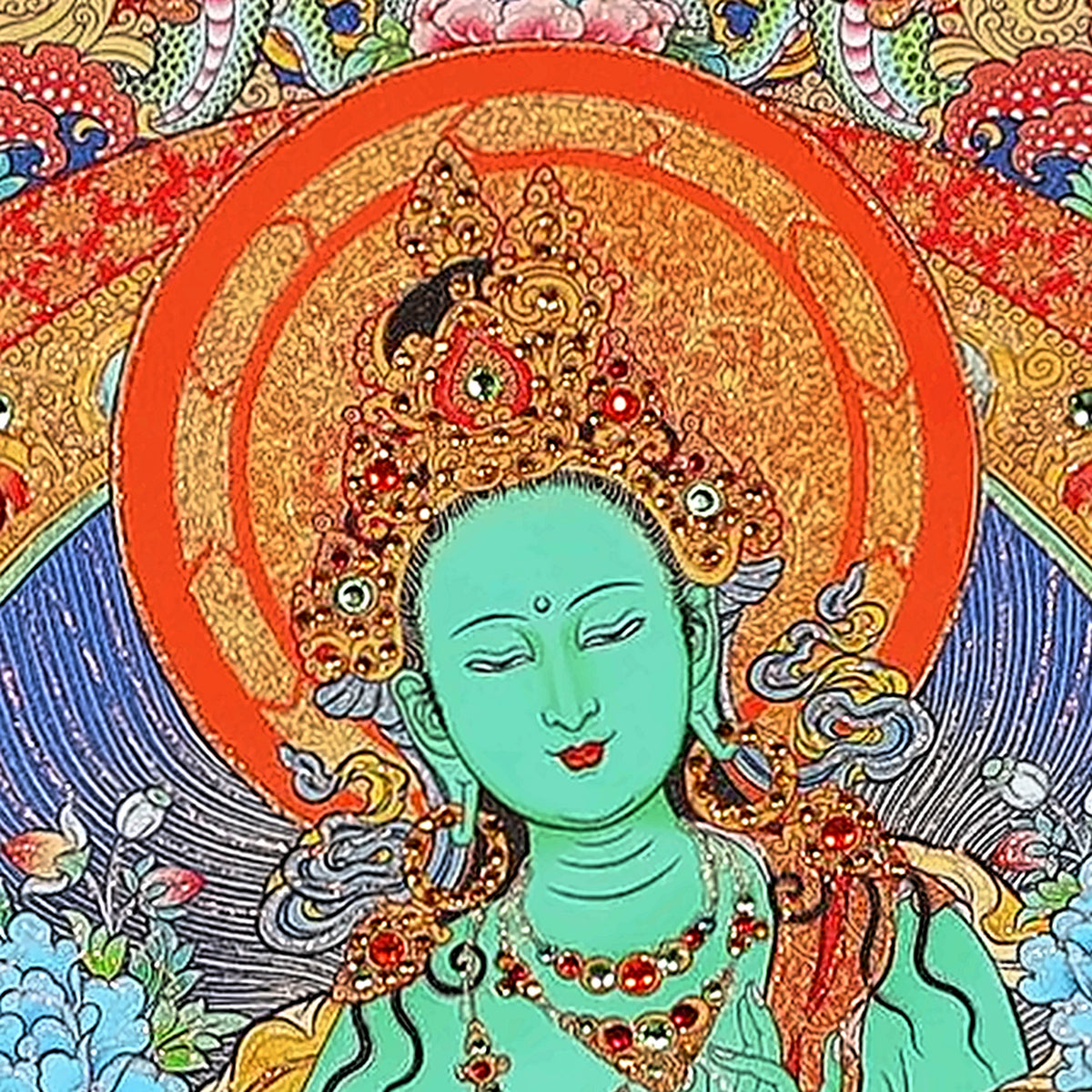 Green Tara thangka detail: green face under a jewelled crown and orange halo