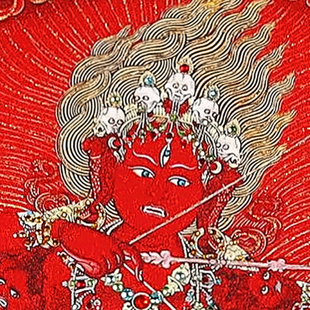 Kurukulla thangka detail: red three-eyed face under a crown of skulls and flaming hair