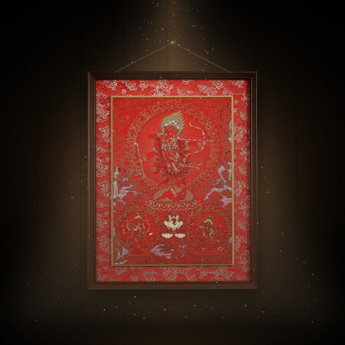 Kurukulla red thangka hanging in a room under warm light