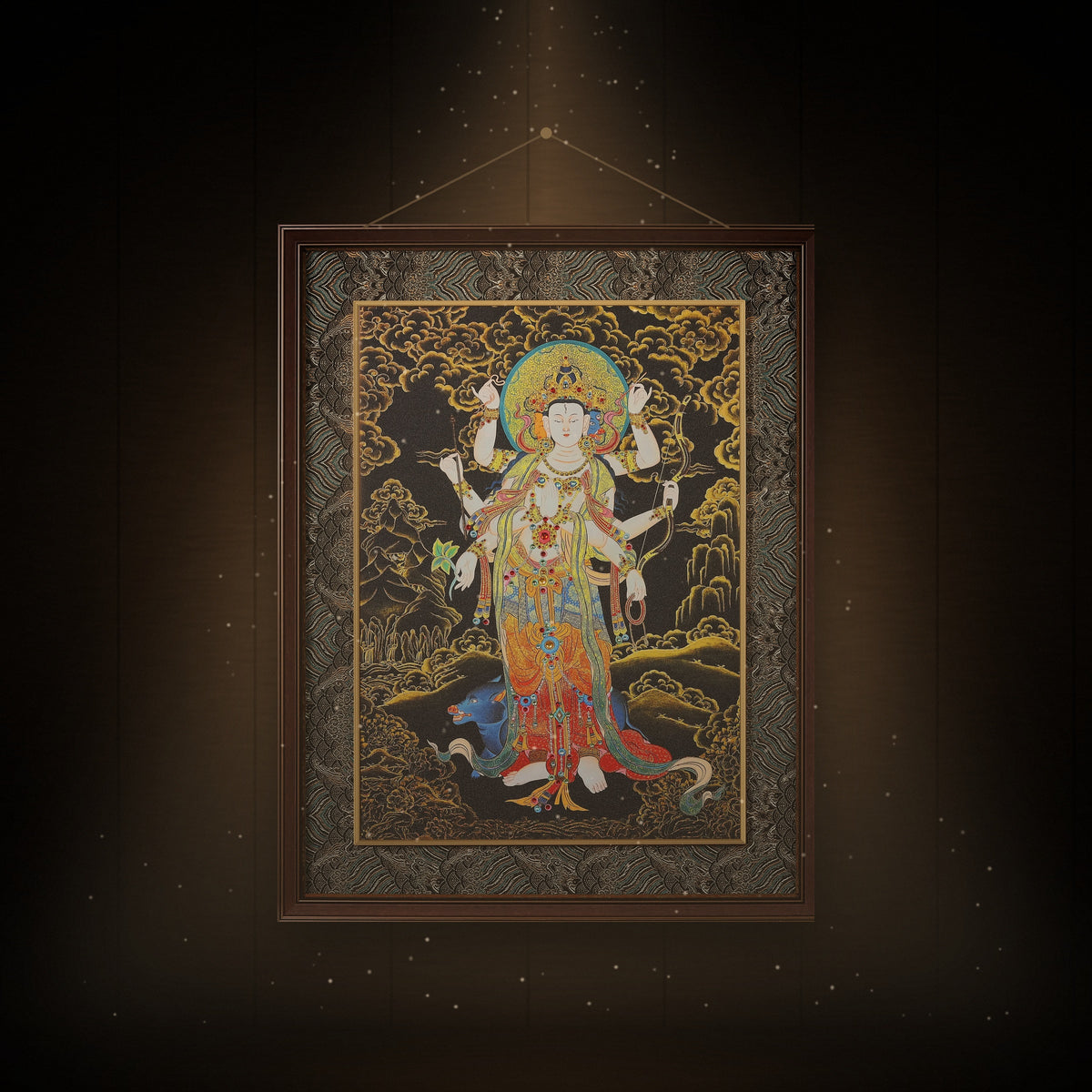 Marici black and gold thangka hanging in a room under warm light