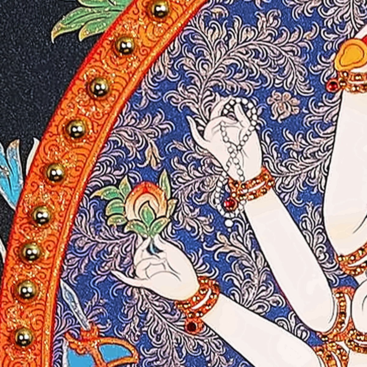 Cundi thangka detail: hand holding a rosary beside the gold halo