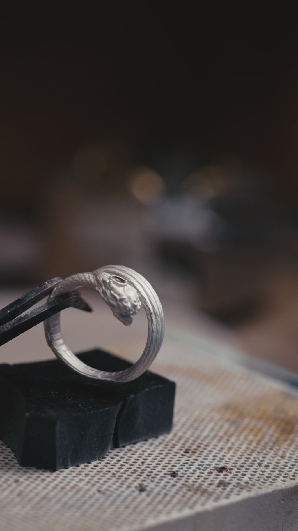 Garuda pinky ring turning in the light, natural garnet in the brow and carved feathers along the band