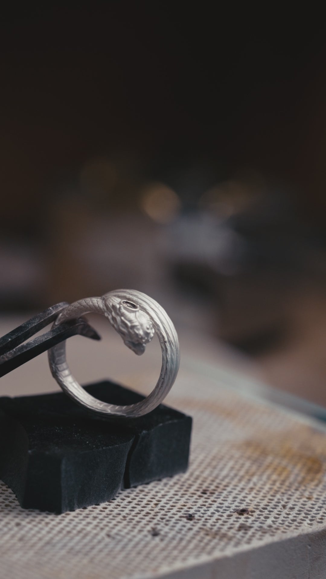 Garuda pinky ring turning in the light, natural garnet in the brow and carved feathers along the band