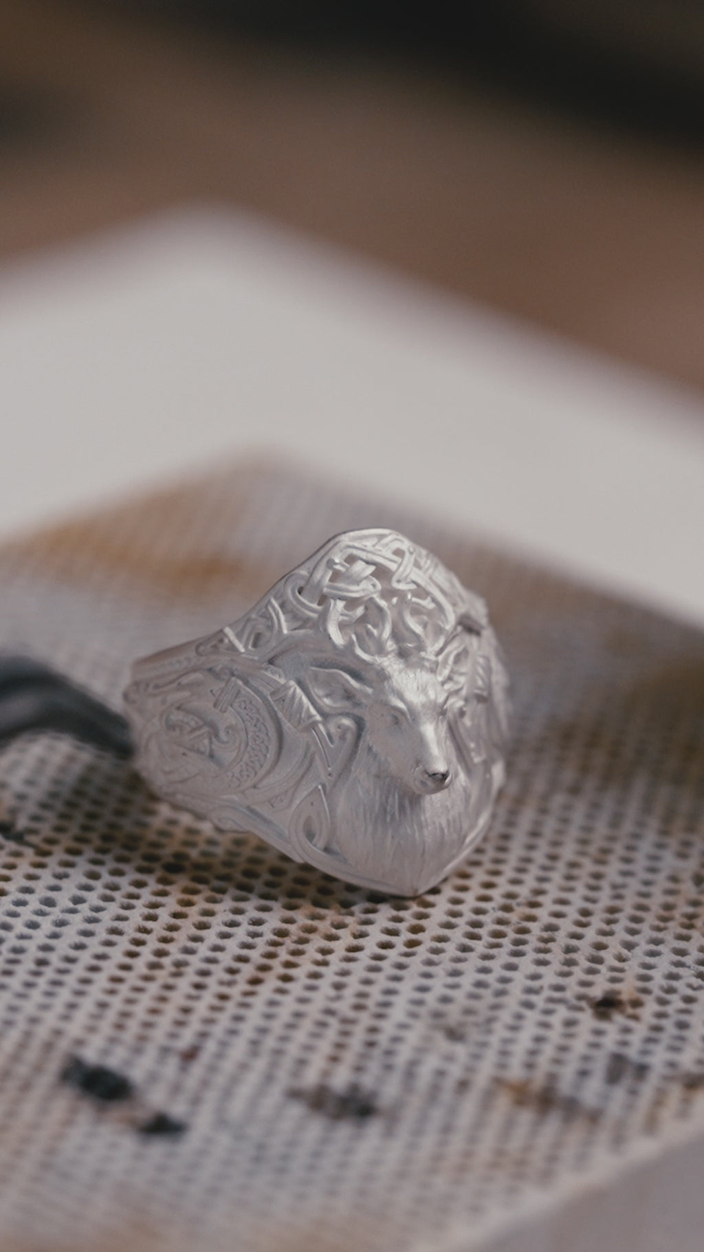Stag ring turning in the light, gilded eyes and Norse runework carved along the sides
